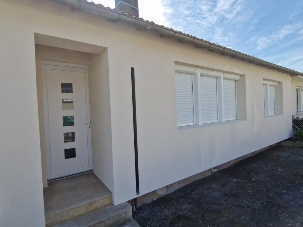 Ravalement Façade et Menuiseries Blanches Maison Moderne Façade de maison moderne avec porte d'entrée blanche, fenêtres à volets roulants et ravalement de mur blanc cassé.